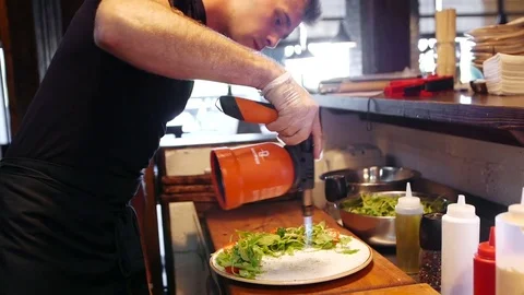 A young modern cook warms up a dish with a gas burner Stock Footage 78723643