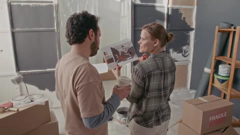 Young Modern Couple Discussing Examples of New Interior of New Apartment Stock Footage 302764025