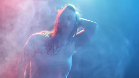 Young modern style dancer on a dark background with smoke and lights Stock Footage 90485560