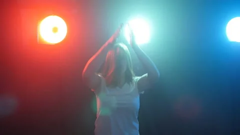 Young modern style dancer on a dark background with smoke and lights Stock Footage 90486889