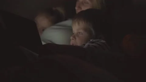 Young mom and her son with daughter watching interesting film together Stock Footage 101581899