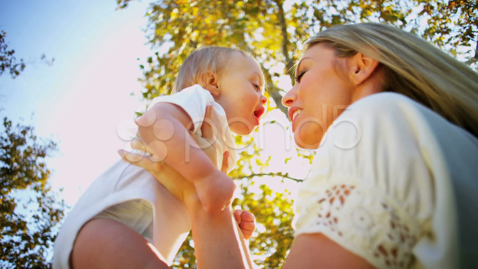 Young Mom Kissing Baby Son Outdoors