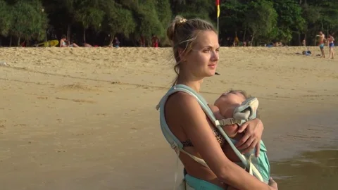 Young Mom Nursing Her Sleeping Baby in Sunset Light. Slow Motion Stock Footage