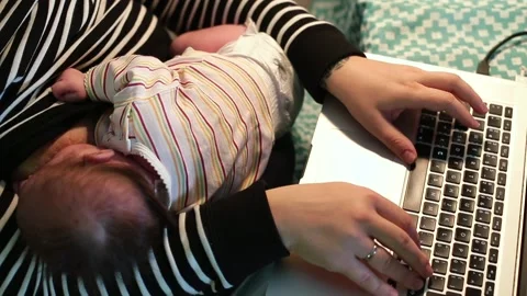 Young mom parent typing text on laptop keyboard. She breastfeeding baby Video stock 151341278
