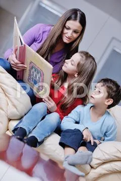Young mom play with their kids at home and reading book Stock Photos