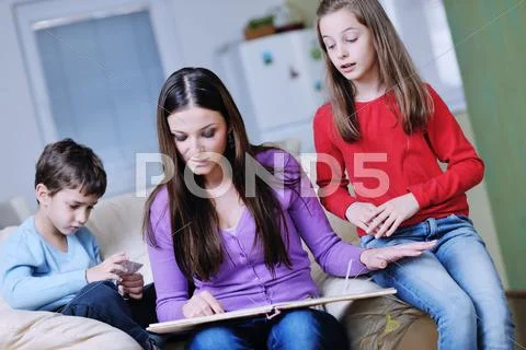 Young mom play with their kids at home and reading book Stock Photos