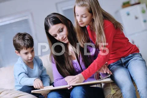 Young mom play with their kids at home and reading book Stock Photos