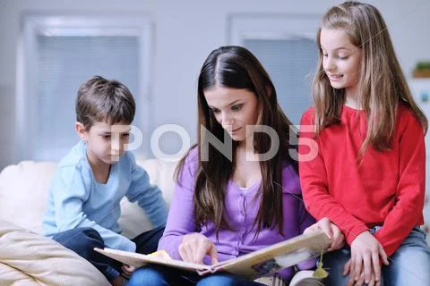 Young mom play with their kids at home and reading book Stock Photos