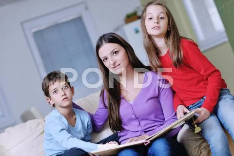Young mom play with their kids at home and reading book Stock Photos