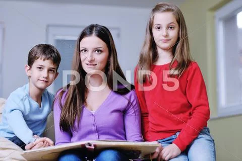 Young mom play with their kids at home and reading book Stock Photos