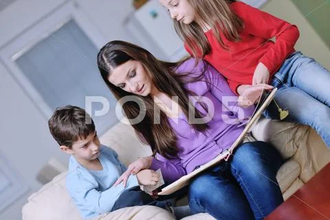 Young mom play with their kids at home and reading book Stock Photos