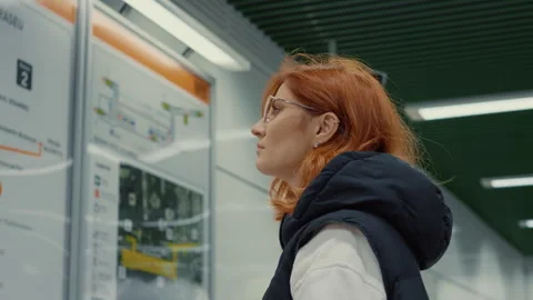 Young mom pushes stroller on subway, checking info boards Stock Footage 317993532