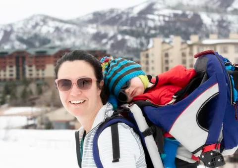 Young Mom Snowshoeing with her Baby in a Backpack Stock Photos