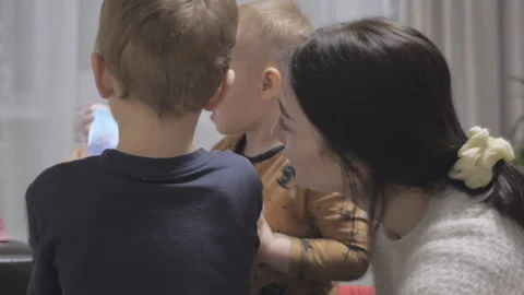 Young mom with two children playing and having fun with smartphone at home Stock-Footage 156021959