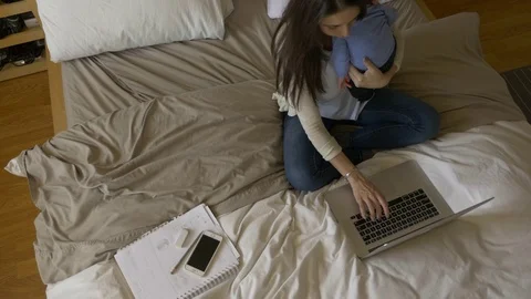Young mom working from home with baby in her arms Stock Footage