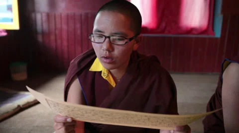 A young monk reading the buddhist script during a ritual. Stock Footage 31637123