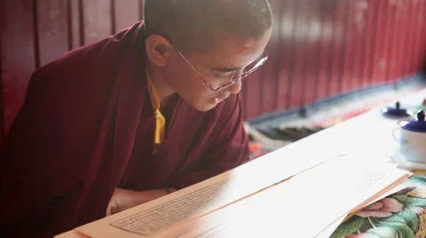 A young monk reading the buddhist script during a ritual. Stock Footage 31708651