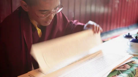 A young monk reading the buddhist script during a ritual. Stock Footage 31708839