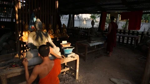 Young monk working on Buddha statue in temple in Luang Prabang, Laos Stock Footage 104120573