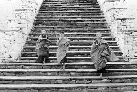 Young monks come down the steps of the ancient Dzong ; monastery at Paro ;... Фото