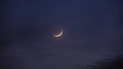 Young moon in the initial phase on a dark night sky, time lapse Stock Photos