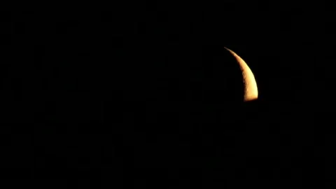The young moon moves fast in the sky behind the roof of the house Video stock 144584798