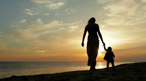 Young mother with 1 year old baby walking on sea coast. Stock Footage