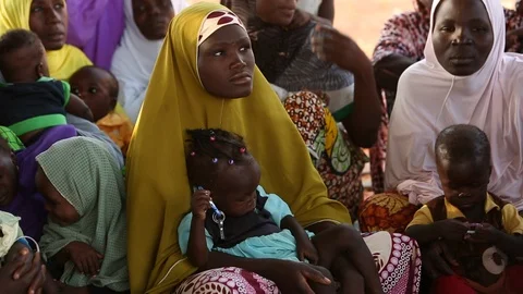 Young mother and child in Islamic dress at a village meeting in Nigeria, Africa Stock Footage