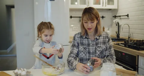Young mother and daughter having fun baking cookies in the kitchen together Stock Footage 146088198