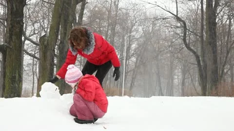 Young mother and daughter playing in the snow Stock Footage 20480853
