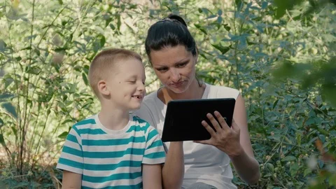 Young Mother And Son Using Tablet PC Watching Funny Photos Stock Footage 69866914