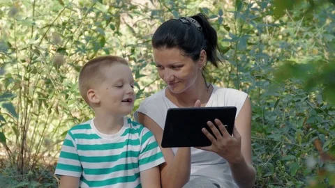 Young Mother And Son Using Tablet PC In The Forest Stock Footage 71929875