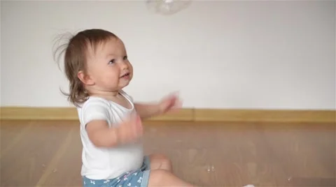 Young mother blowing bubbles for his daughter, the girl laughing and having fun Stock Footage 63430630