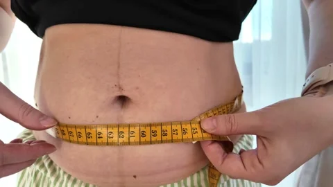 Young mother checking abdominal size after delivery. Concept of recovery Stock Footage 329572802