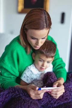 Young mother checking temperature to son Foto stock