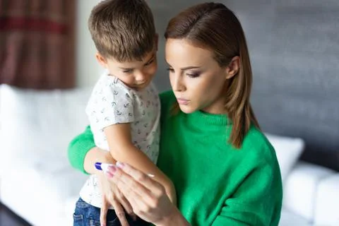 Young mother checking temperature to son horizontal Stock Photos