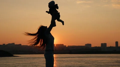 A young mother cheerfully throws up her little son. Mother and child having fun Stock Footage 92818814