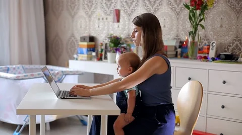 Young Mother with a Child Working on a Computer Stock Footage 52158989