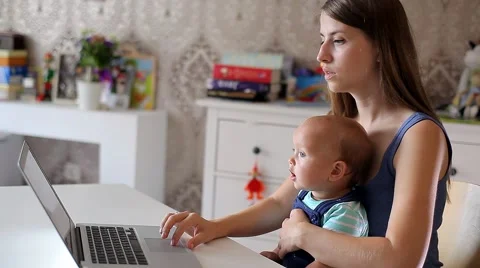 Young Mother with a Child Working on a Computer Video stock 52159052