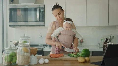 Young mother cook dinner with her little daughter, maternity leave Stock Footage 126358979