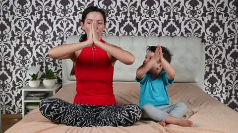 Young mother does yoga exercises and have fun together with her toddler boy. Stock Footage 151500618