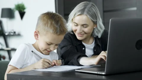 Young mother doing homework with her son pointing to something written Stock Footage 157815019