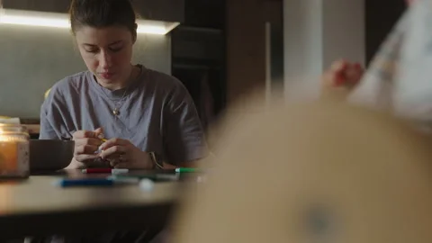 Young mother drawing Easter eggs with her child girl daughter and son at kitchen Stock Footage 250526103