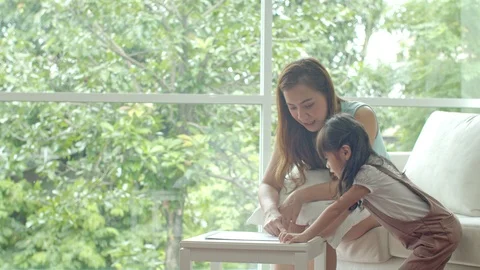 Young mother drawing on paper while teaching her daughter Stock Footage 119405593