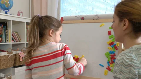 Young mother explaining arithmetic to cute little daughter at home Stock Footage 85834570