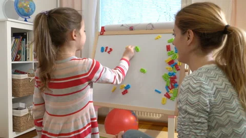 Young mother explaining arithmetic to cute little daughter at home Stock Footage 85838231