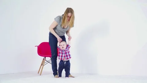 Young mother halping her 6 months to make the first steps Stock Footage 75020570