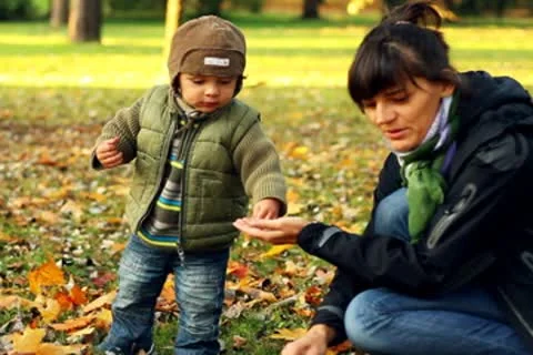 Young mother having fun with her son in beautiful autumn park Stock Footage 8950918