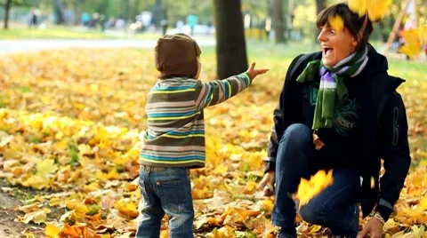 Young mother having fun with her son in autumn park, slow motion Stock Footage 8950987