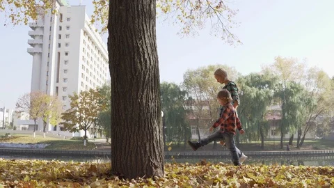 Young mother having fun with her son in autumn park at sunny day Video stock 97093773
